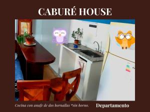 una cocina con mesa y nevera con búhos. en Caburé House en Salta