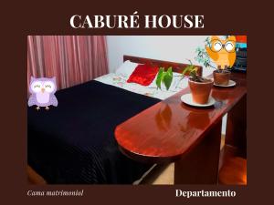 Un dormitorio con una cama y una mesa con dos búhos. en Caburé House en Salta