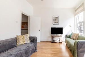 a living room with two couches and a flat screen tv at Large, Bright and Spacious 3 Bed Flat in London in London