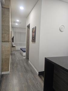 um quarto com um corredor com paredes brancas e pisos em madeira em Edificio Lotus Loft em Cali