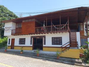 un edificio con balcón y escalera. en Hotel El Albergue Español en Puerto Misahuallí