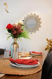 a table with a vase of flowers and a mirror at Your 2BR Luna Retreat with Beach Access in Al Rahba in Abu Dhabi