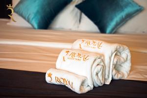 a stack of towels sitting on top of a bed at Your 2BR Luna Retreat with Beach Access in Al Rahba in Abu Dhabi