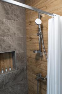 een douche met een douchegordijn in de badkamer bij Lux Apartment III Prijedor in Prijedor