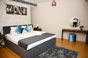 - une chambre avec un lit doté d'oreillers bleus et d'un miroir dans l'établissement Your 2BR Luna Retreat with Beach Access in Al Rahba, à Abu Dhabi