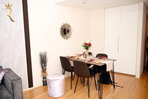 a dining room table and chairs in a room at Luna Breeze - Elegant 2BR Apartment with Beach Access, Near Al Raha Beach in Abu Dhabi