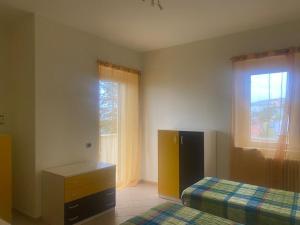 - une chambre avec 2 lits, une commode et une fenêtre dans l'établissement La Casa di Anna, à Avilla