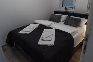 a bedroom with a bed with two towels on it at Lux Apartment III Prijedor in Prijedor