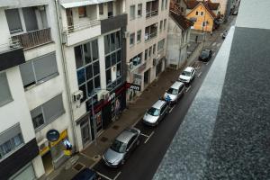 a group of cars parked on a city street at Lux Apartment III Prijedor in Prijedor