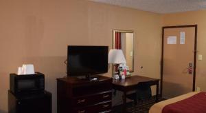 a hotel room with a bed and a television and a desk at Richburg Inn in Richburg