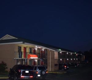 une voiture garée devant un bâtiment la nuit dans l'établissement Richburg Inn, à Richburg