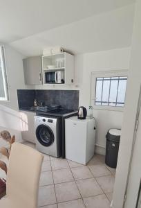 une cuisine avec un lave-linge et un lave-linge dans l'établissement PR2e, au Blanc-Mesnil