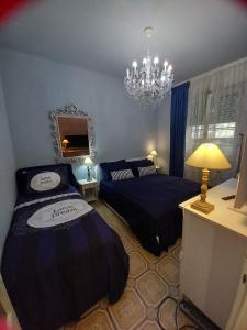 a bedroom with two beds and a chandelier at Italian Vintage House in Como