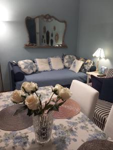 una sala de estar con una mesa con un jarrón de flores en Italian Vintage House, en Como