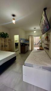 a large room with two beds and a kitchen at Área vip maranduba in Ubatuba