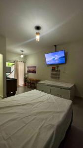 a bedroom with a bed and a flat screen tv at Área vip maranduba in Ubatuba