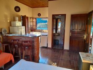 a kitchen with a table and a counter top in a room at Chalé Mirante Da Guapiara in Aiuruoca