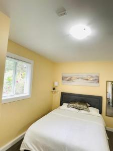 a bedroom with a white bed and two windows at Garden home in Victoria -Beautiful home in Victoria in Victoria