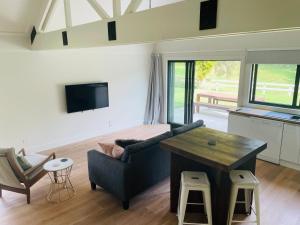 a living room with a couch and a table at Stunning 2 bedroom Guesthouse in Tamahere