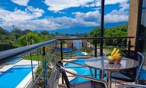 balcón con mesa, sillas y piscina en Hermosa vista - Wifi gratis - Refugio del Edén Apartasol, en La Tebaida