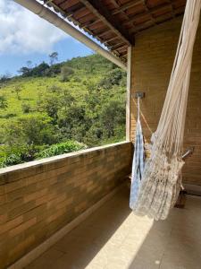 a hammock on a porch with a view of a hill at Lar do sertão- flat dentro do Hotel Fazenda Pedra do Rodeadouro in Bonito