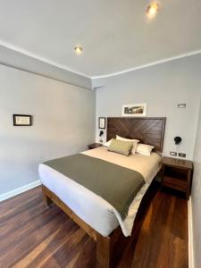 1 dormitorio con 1 cama grande y cabecero de madera en Casa Montes San Blas, en Cusco