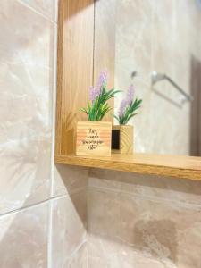 una estantería de madera en un baño con flores. en Lar do sertão- flat dentro do Hotel Fazenda Pedra do Rodeadouro, en Bonito