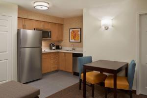 uma cozinha com uma mesa e um frigorífico de aço inoxidável em Residence Inn by Marriott Toronto Airport em Toronto