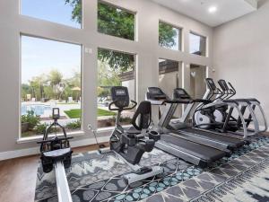 a gym with several treadmills and elliptical machines at Luxury Vacation Rentals by Meridian CondoResorts in Scottsdale