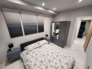 a bedroom with a bed and two windows at Billie Island apartments in Slaithwaite
