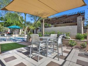 a table and chairs under an umbrella on a patio at Luxury Vacation Rentals by Meridian CondoResorts in Scottsdale