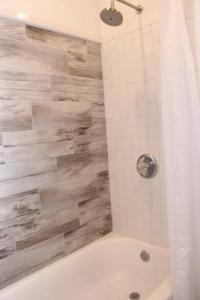 a bathroom with a shower with a white bath tub at Elegant 3Br Apt Yankee stadium in Melrose