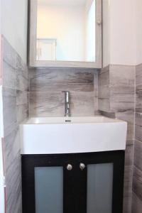 ein Badezimmer mit einem weißen Waschbecken und einem Spiegel in der Unterkunft Elegant 3Br Apt Yankee stadium in Melrose