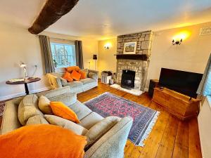 a living room with a couch and a fireplace at Springbank Cottage in Stroud