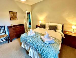 a bedroom with a bed with two swans on it at Springbank Cottage in Stroud