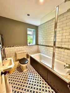ein Badezimmer mit einer Badewanne, einem WC und einem Waschbecken in der Unterkunft Springbank Cottage in Stroud