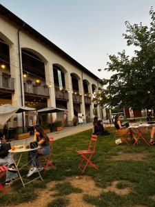 a group of people sitting at tables in front of a building at Sweet Home in Milano smart district in Milan