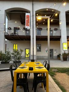 a yellow table with chairs in front of a building at Sweet Home in Milano smart district in Milan