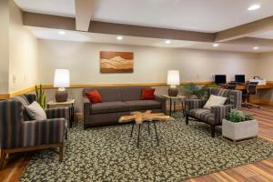 a waiting room with a couch and chairs and a table at Best Western Plus Windjammer Inn & Conference Center in Burlington