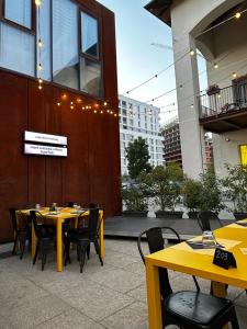 a restaurant with yellow tables and chairs in front of a building at Sweet Home in Milano smart district in Milan