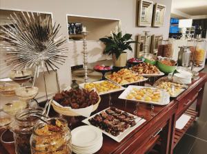 ein Buffet mit vielen verschiedenen Speisen auf dem Tisch in der Unterkunft DoubleTree by Hilton Cape Town Upper Eastside in Kapstadt