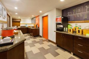 a large kitchen with orange accents in a restaurant at Hampton Inn Cincinnati Airport-North in Hebron