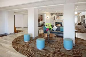 Homewood Suites by Hilton Dallas Market Center في دالاس: لوبي فيه كنب وطاولة وموقد