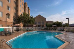 a large swimming pool with chairs and a building at Homewood Suites by Hilton Dallas Market Center in Dallas