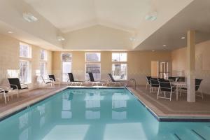 a large swimming pool with chairs and a table at Hampton Inn & Suites Mystic in Mystic