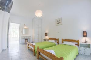 a bedroom with two beds with green sheets at Olive Grove Apts in Lithakia