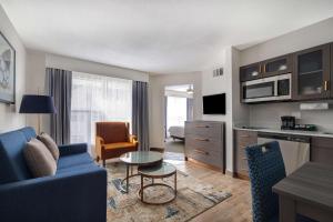 a living room with a blue couch and a table at Homewood Suites by Hilton Jackson-Ridgeland in Ridgeland