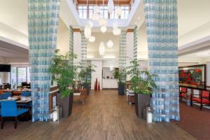 a lobby with tables and potted plants at Hilton Garden Inn Tallahassee in Tallahassee