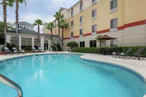 une grande piscine en face d'un bâtiment dans l'établissement Hilton Garden Inn Tallahassee, à Tallahassee