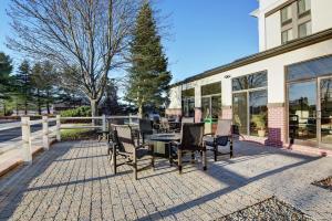 a patio with chairs and tables on a brick patio at Hampton Inn Portsmouth Central in Portsmouth